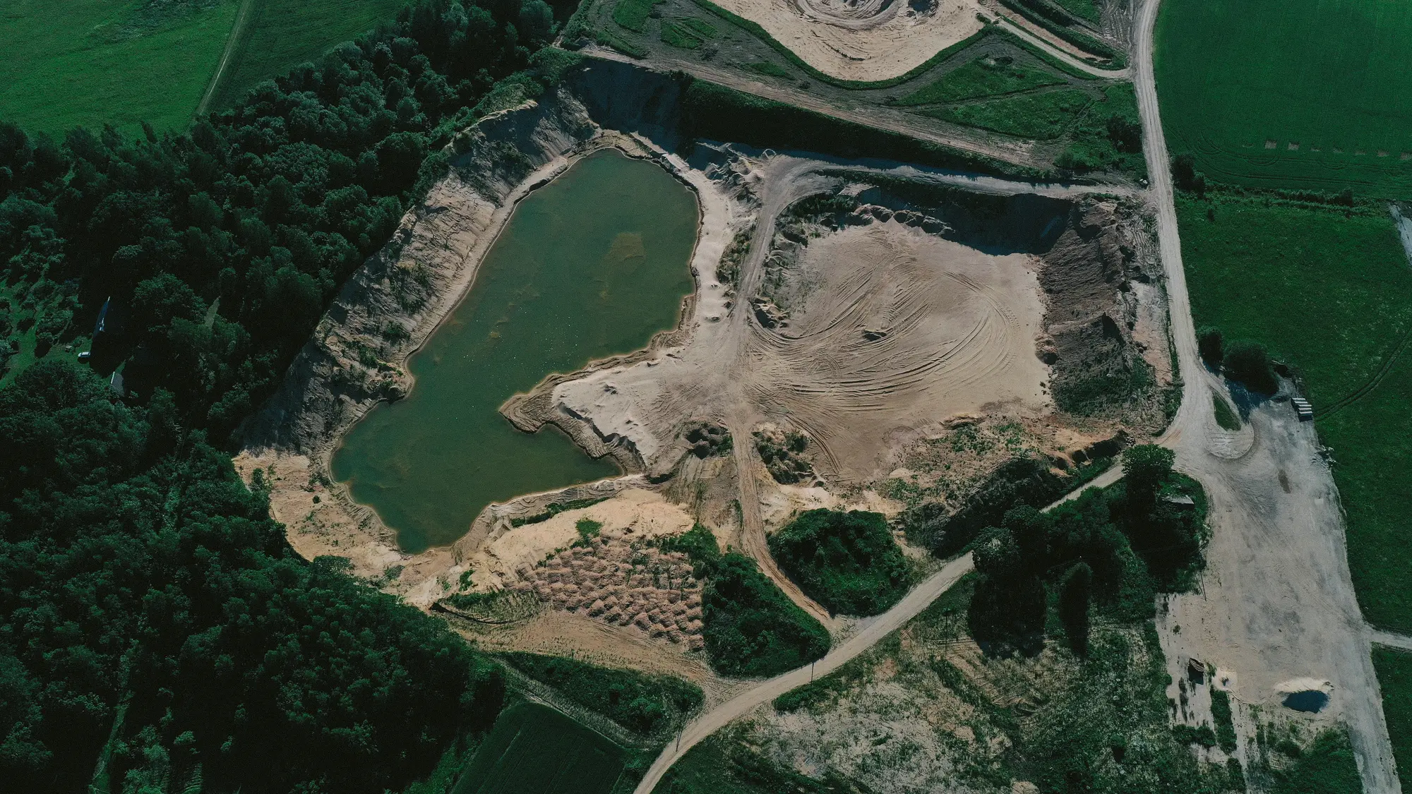 Aerial view of a quarry with a lagoon surrounded by forest