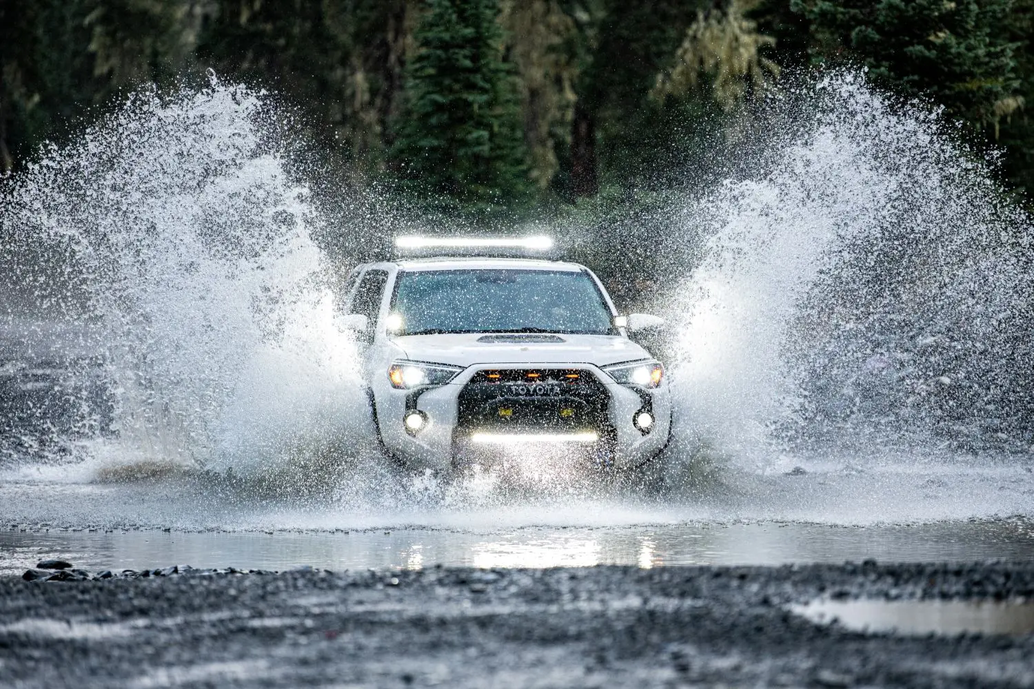 4x4 truck crossing a stream on a field road